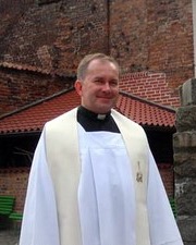 ks. kan. Ludwik Kowalski w komży i stule przed bazyliką św. Brygidy